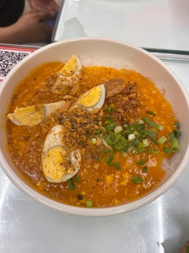 Palabok topped with egg and chicharon